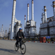An Iranian oil worker rides his bicycle at the Tehran oil refinery, south of the capital Tehran, Iran. Across a Mideast fueled by oil production, low global prices have some countries running on empty and scrambling to cover shortfalls, even as more regional crude is on tap to enter the market.